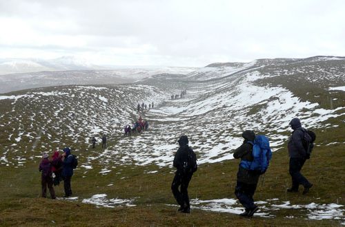 Walkers cross Wold Fell in snow